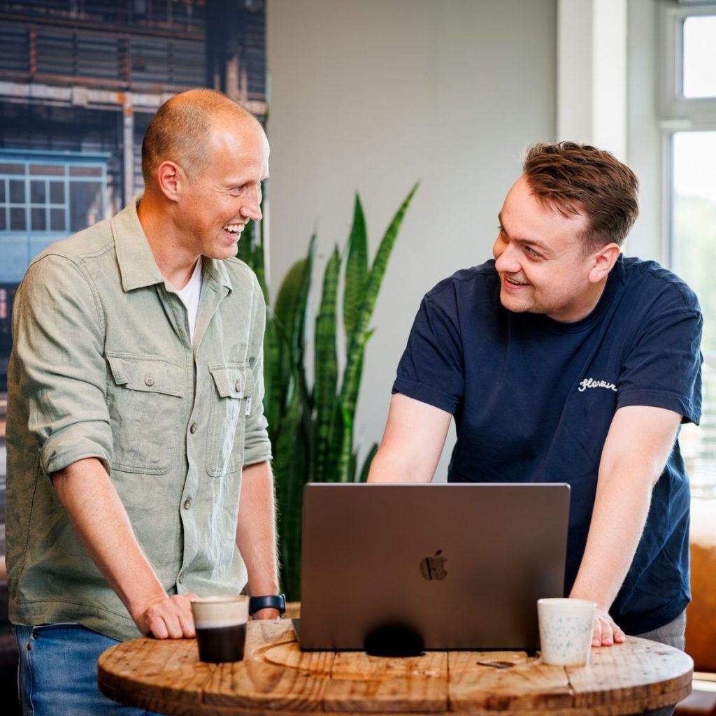Specialisten van Mooi Online bekijken samen een webshop op een laptop